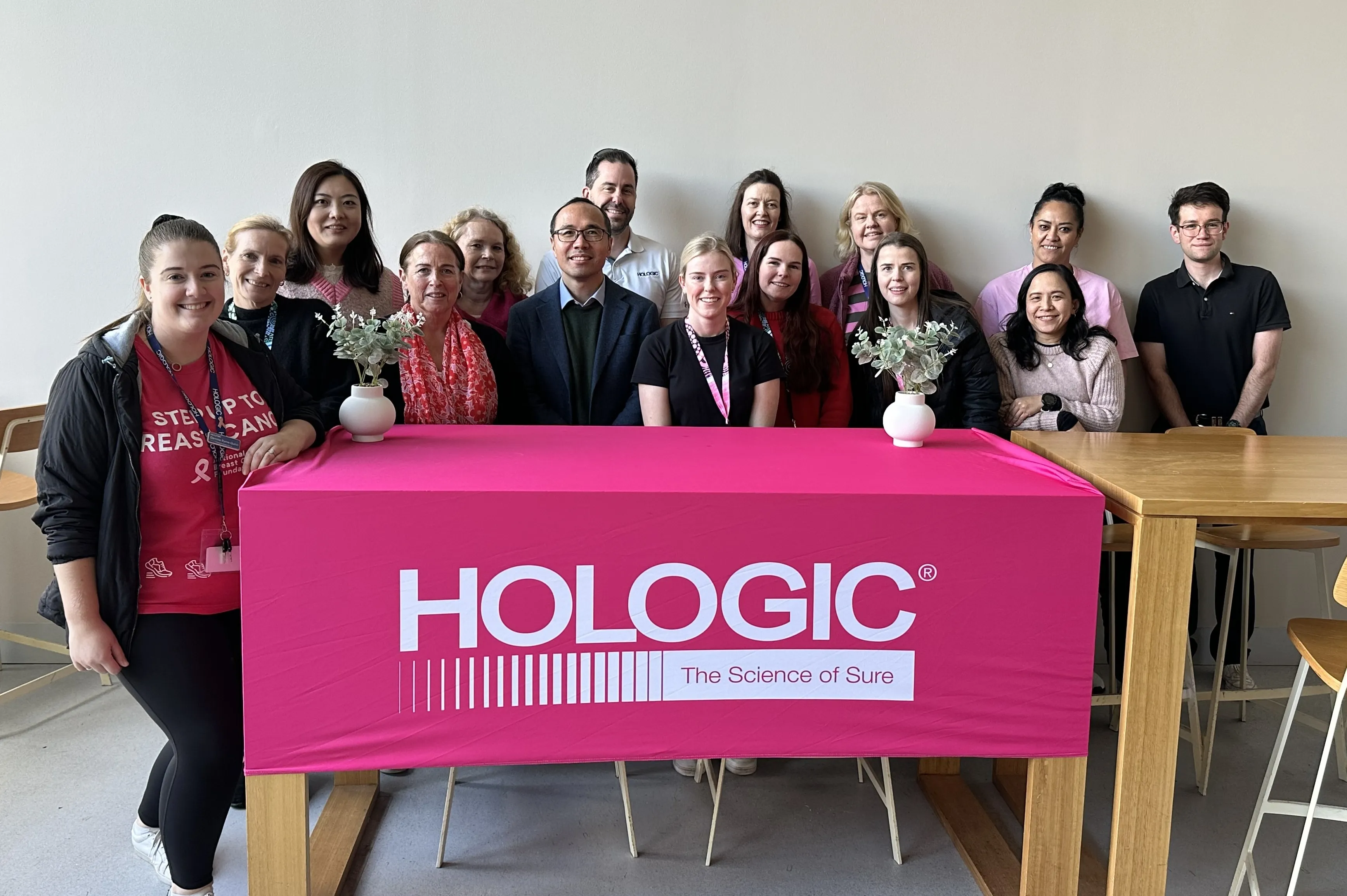 Hologic ANZ Team behind a table with a Hologic banner